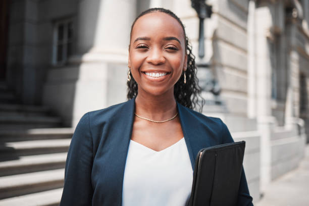 Happy black woman, lawyer and portrait smile in confidence for career ambition in the city. Face of African female person or business attorney in happiness or pride for job opportunity in urban town